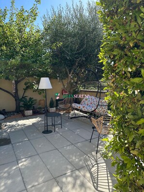An outdoor patio with a table and chairs, a lamp, and a sign that reads 'GRUPPO SERENI'. - Villa on Pian degli olivi - Ref. Villa Eva-Rif. VillaEva (San Vincenzo)