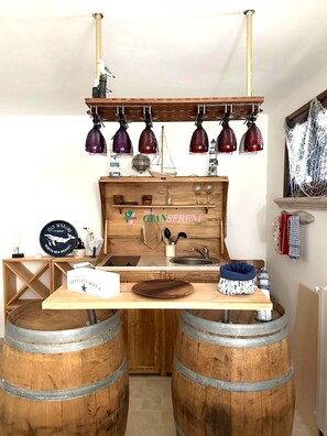 A rustic kitchen with wooden barrels, a wooden counter, hanging red lamps, and a sign reading 'Old Whaling North Sea Market.' - Villa on Pian degli olivi - Ref. Villa Eva-Rif. VillaEva (San Vincenzo)