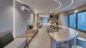 A modern interior with a curved bar, seating areas, and a view through large windows.