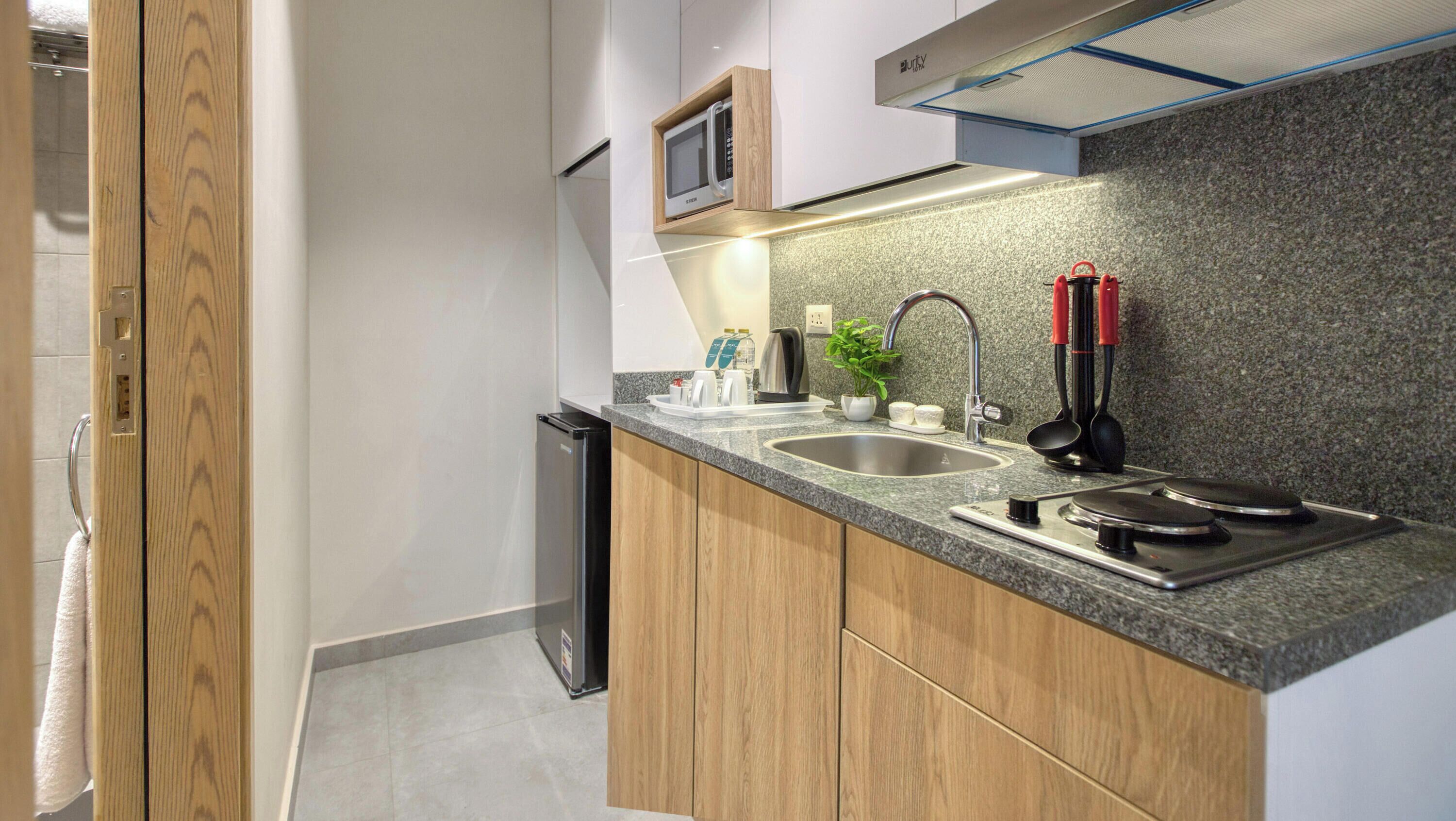 Una cocina moderna con microondas integrado, un fregadero y una estufa.