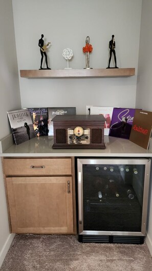 A compact living space with a wooden cabinet, a vintage radio, and decorative figurines on a shelf.