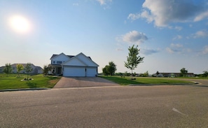 A residential street with houses, a clear sky, and a sunny day. - Pet-Friendly Faribault Home • Near Shattuck-St. Mary's (Faribault)