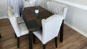 Ein Essbereich mit Tisch, Stühlen und einem Stadtbildgemälde.