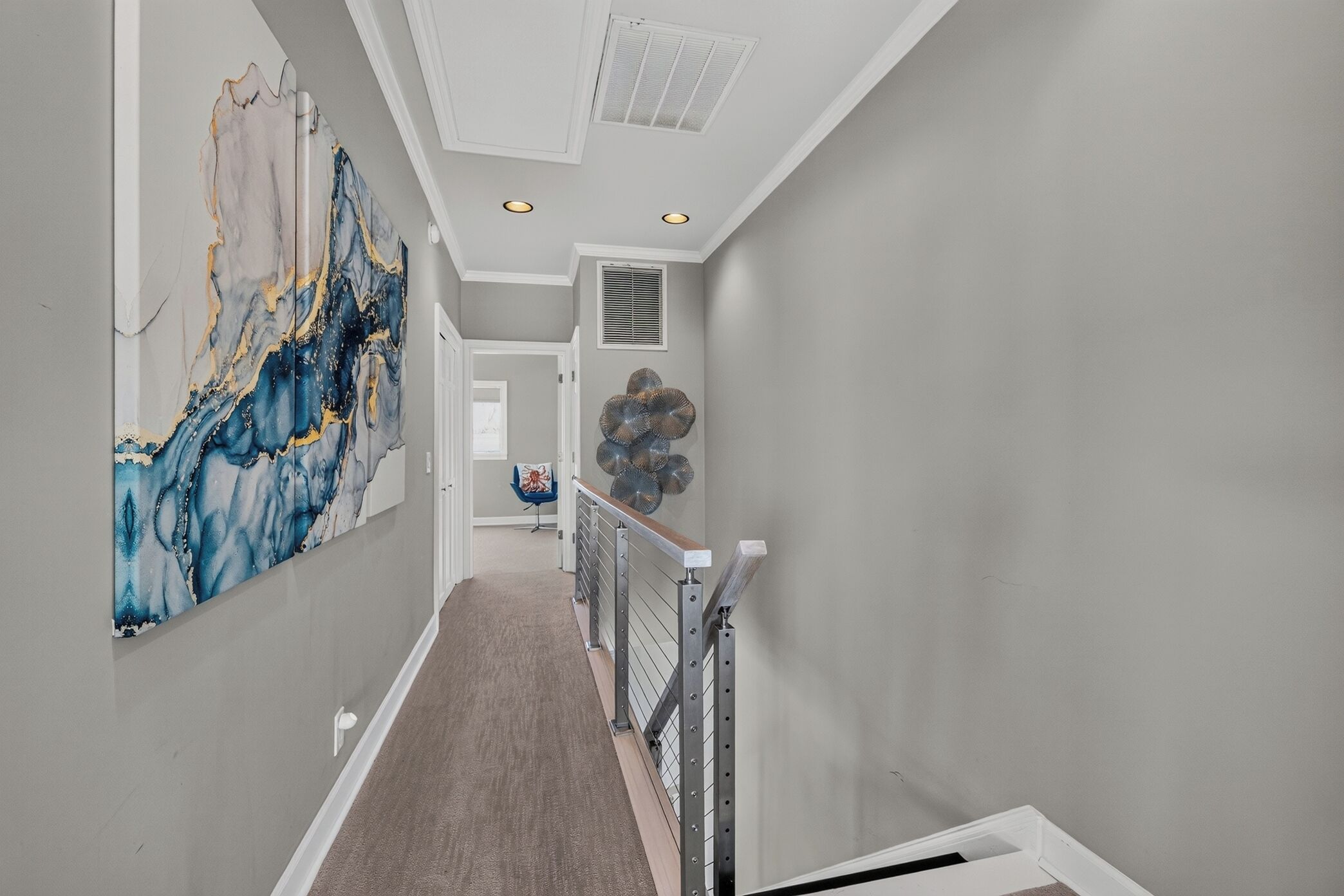 Un couloir orné d’un décor mural en marbre, avec un escalier et un élément décoratif mural.