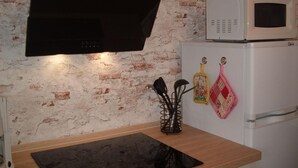 A kitchen with a black range hood, a white microwave, and a refrigerator. - Maria Vacation Rental 3 – Cozy, Central, and Ideal for Families (Wernigerode)