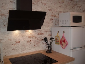 A kitchen with a black range hood, a white microwave, and a refrigerator. - Maria Vacation Rental 3 – Cozy, Central, and Ideal for Families (Wernigerode)