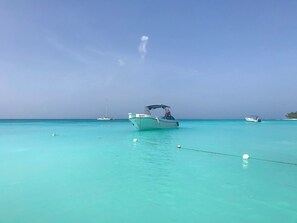 Un bateau sur une eau turquoise, sous un ciel dégagé.