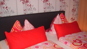 A bed with a patterned bedspread and multiple pillows. - Maria Vacation Rental 1 – Cozy Accommodations with a Warm, Inviting Atmosphere (Wernigerode)