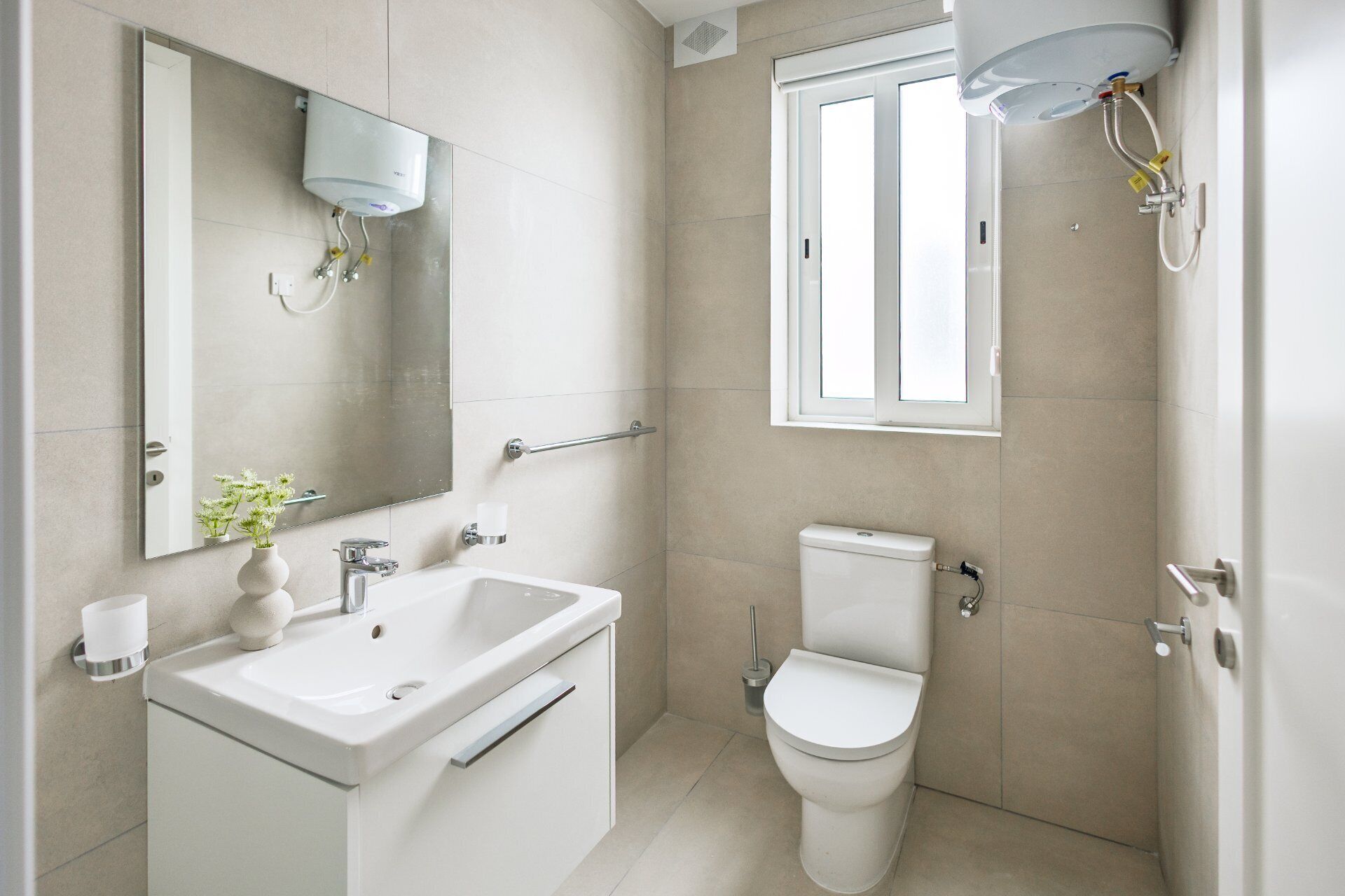 Ein Badezimmer mit Waschbecken, Spiegel, Toilette und Dusche.