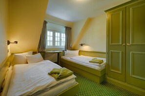 A hotel room with two beds, a window with curtains, a wardrobe, and a small table. - Ferienwohnung in Damerow auf Usedom (Koserow)