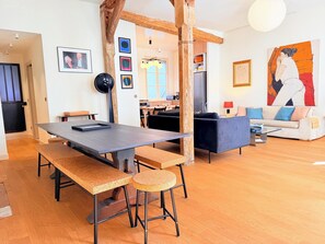 Ein zeitgemäßer Wohnraum mit Essbereich, einer Couch und Kunstwerken an den Wänden.