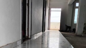 A corridor with a shiny marble floor, leading to a room with a large window. - Raj Mahal Palace (Sitapur)