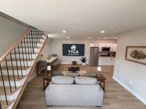 A spacious living area with a staircase, a dining area, and a kitchen. - #33- Newly Constructed - Luxury Collection (Plymouth)