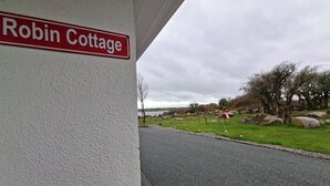Et skilt med teksten 'Robin Cottage' på en bygnings facade.