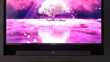 A flat-screen TV mounted on a wall with a fireplace below it.