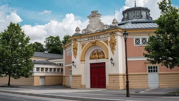 Ein Gebäude mit roter Tür, aufwendiger Goldverzierung und einem Glockenturm.