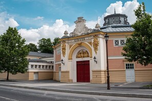 Ein Gebäude mit roter Tür, aufwendiger Goldverzierung und einem Glockenturm.