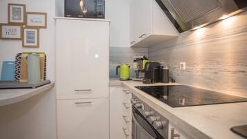 Una cucina moderna con forno a microonde, bollitore e macchina del caffè sul piano di lavoro.