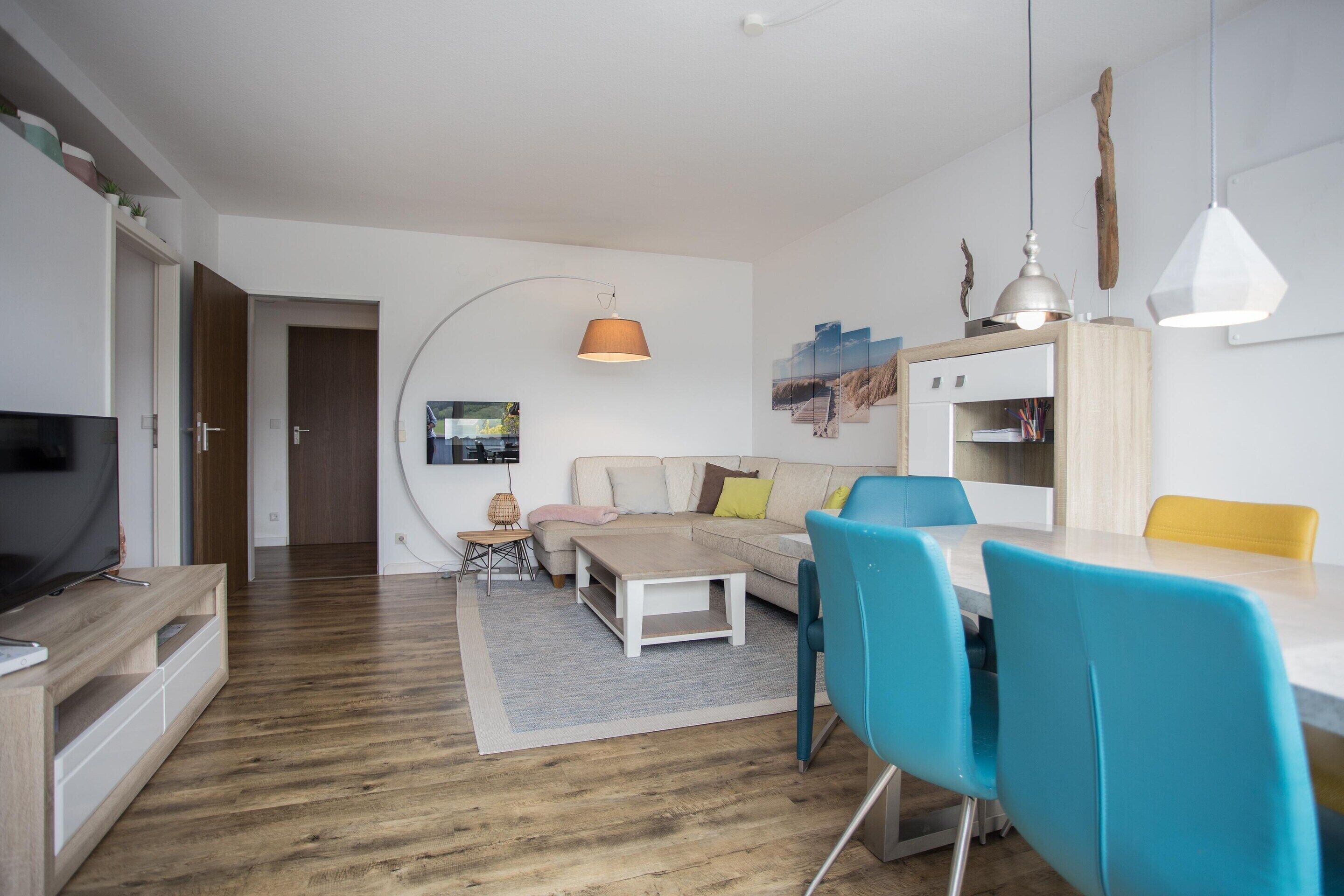 Una sala de estar moderna con un sofá, una mesa de centro y un comedor con sillas.