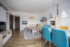 Una sala de estar moderna con un sofá, una mesa de centro y un comedor con sillas.