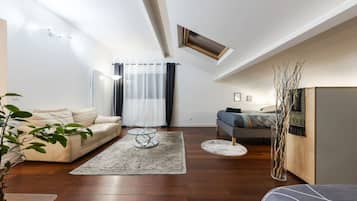 Un salon moderne avec un canapé, une table basse et un lit doté d’une tête de lit.