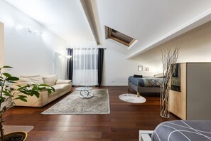 Un salon moderne avec un canapé, une table basse et un lit doté d’une tête de lit.