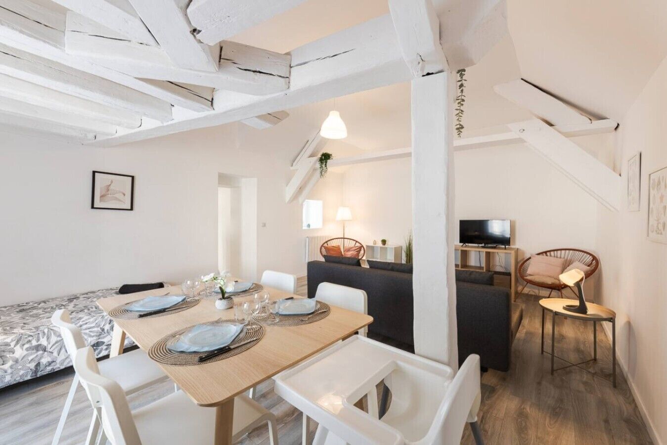 Un ambiente moderno con zona pranzo, divano e televisore.