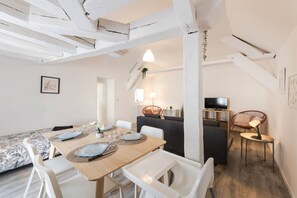 En modern inredning med ett matområde, en soffa och en tv.