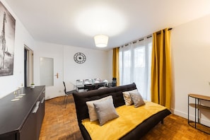 Une chambre à coucher avec un lit, un bureau, une chaise, une table à manger et une horloge au mur.