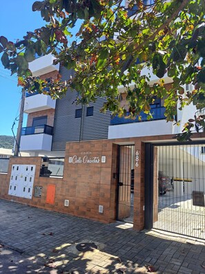 A building with a gated entrance, a sign reading 'Cielo Gaiutas,' and a brick wall with electrical panels. - GREAT APARTMENT IN NORTH ENGLISH BEACH (Ingleses do Rio Vermelho)