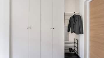 A white wardrobe with a hanging rack and a shoe rack.