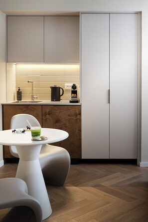 Una cocina moderna con encimera blanca, cafetera y hervidor.