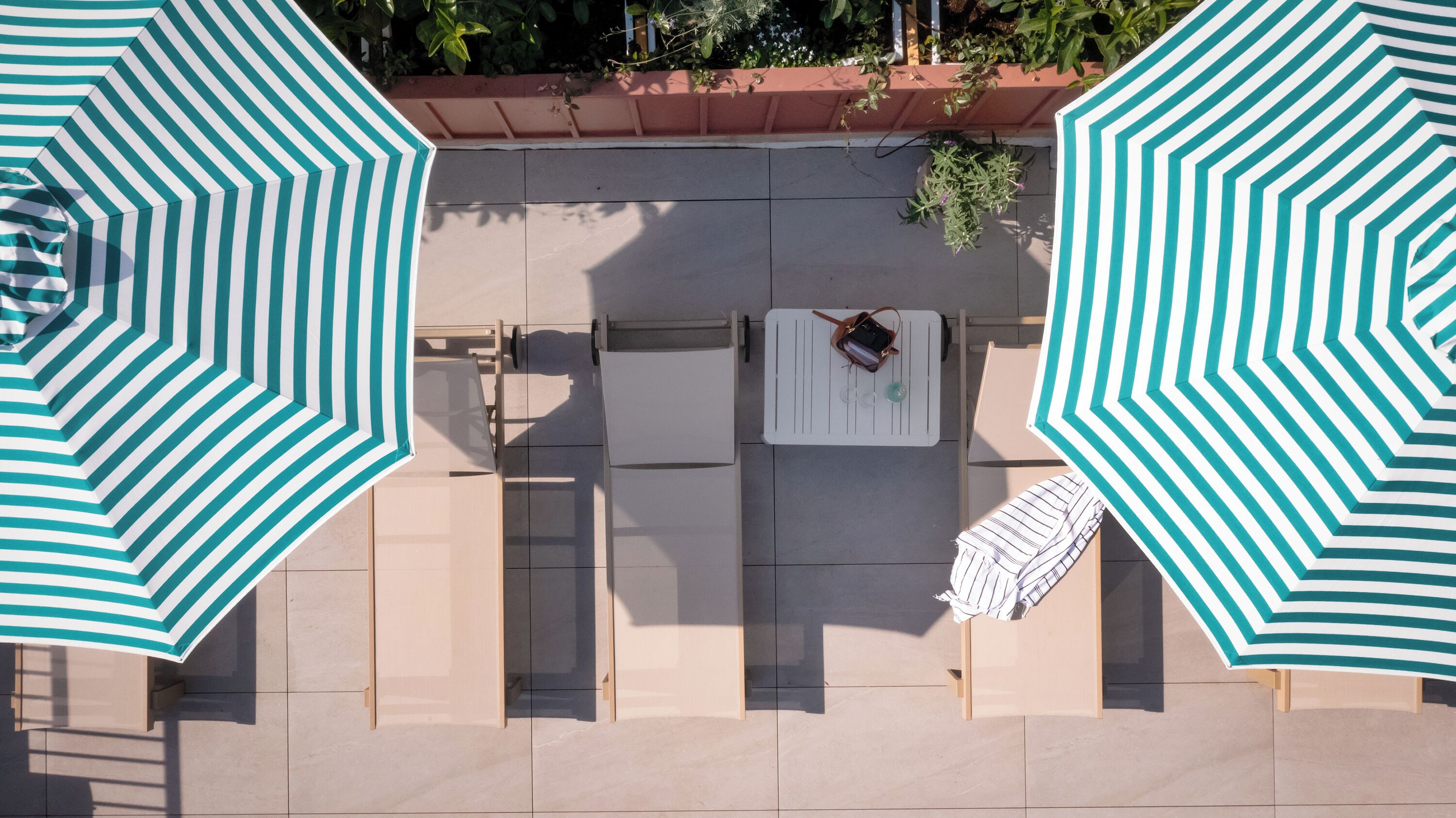 An outdoor seating area with striped umbrellas, a table, and chairs.