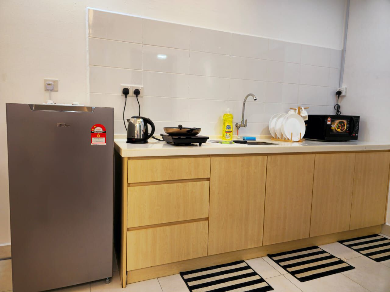A kitchen with a refrigerator, stove, microwave, and sink.