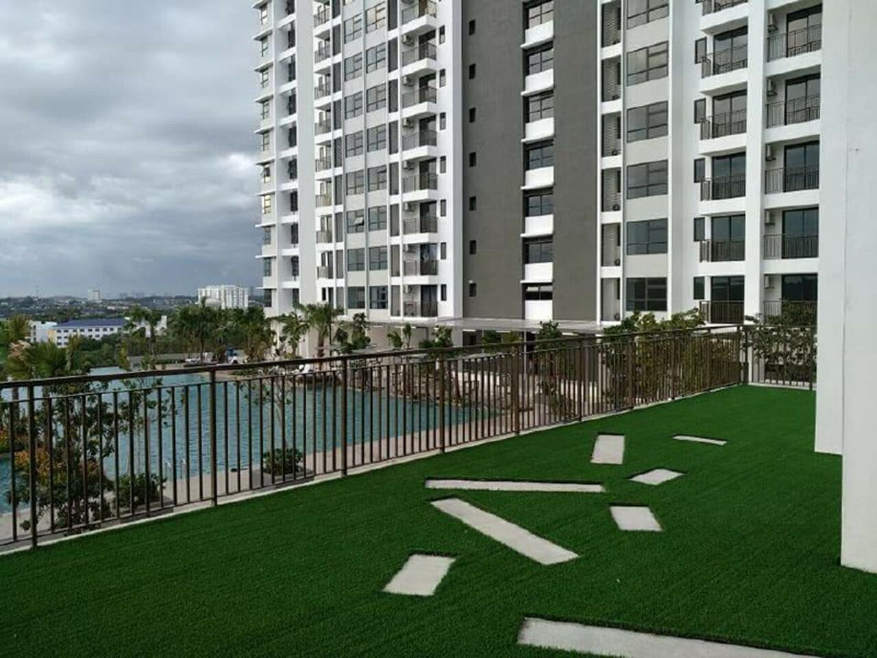 Un edificio alto con balcones, piscina y vistas a la ciudad.