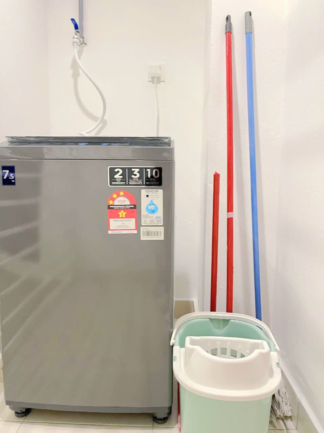 A refrigerator with a digital display, a water dispenser, and a mop bucket.