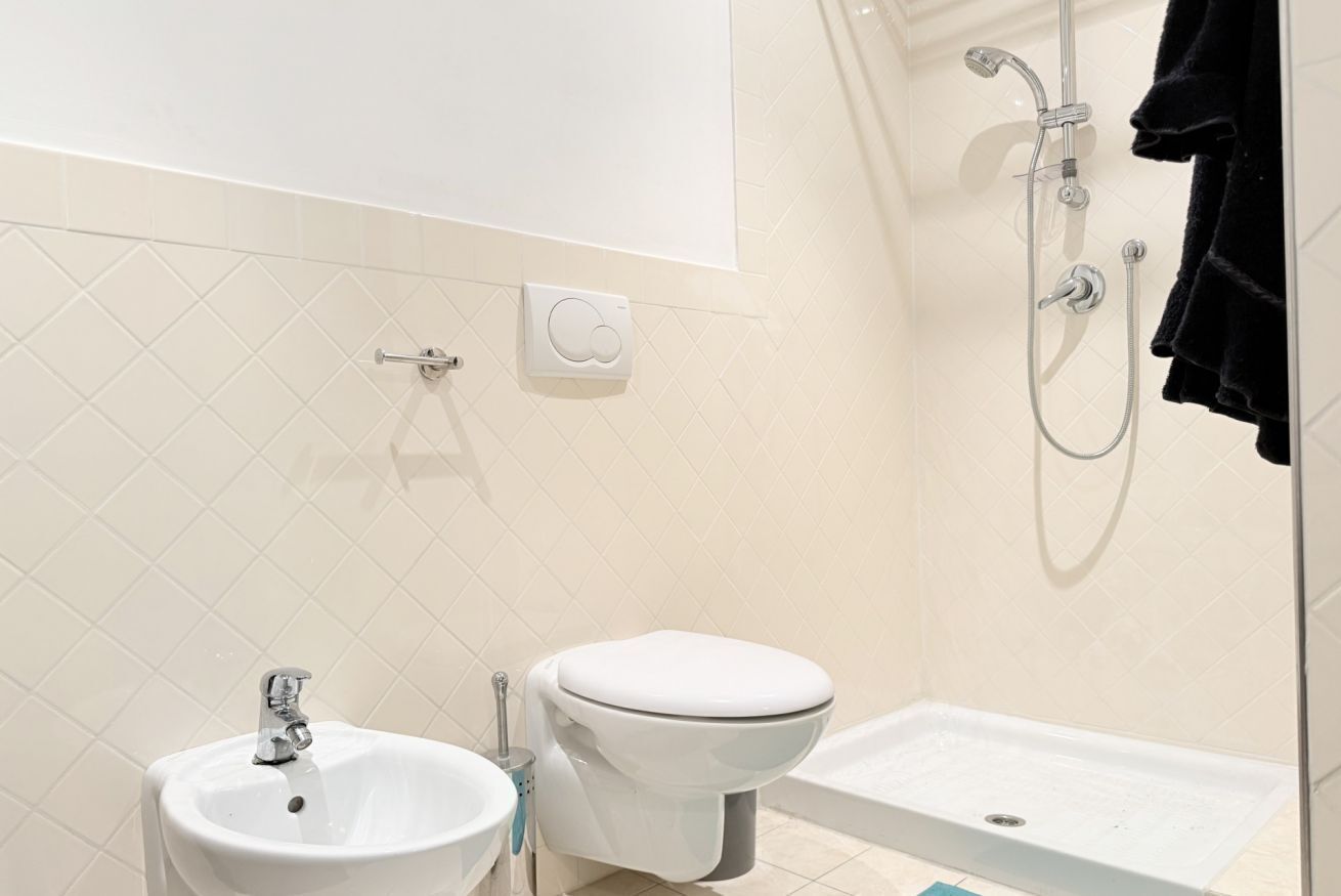 A bathroom with a sink, toilet, and shower.