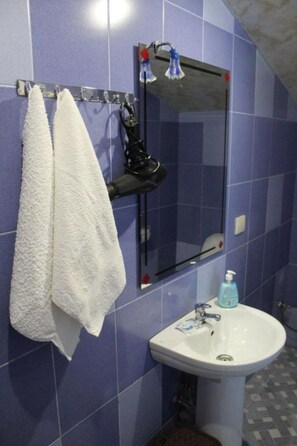 Een badkamer met een wastafel, spiegel en handdoekhouder.