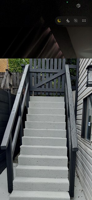 A staircase with wooden railings leading to a house.