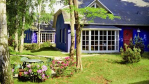 A house with a large window, a door, and a small garden with flowers. - Doppelhauser am Strand auf Usedom in Uckeritz (Ueckeritz)