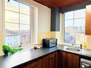 A kitchen with two large windows, a toaster, a sink, and a dishwasher. - Central 4Bed, Caledonian Stay, Haymarket, Sleeps 8 (Edinburgh)