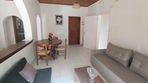 A living room with a sofa, a dining table with chairs, a wooden ceiling, and a door. - Antistoni Cozy  house in beautiful Agros with AC (Agros)