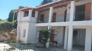A two-story building with a balcony, a small garden, and a metal gate. - Antistoni Cozy  house in beautiful Agros with AC (Agros)