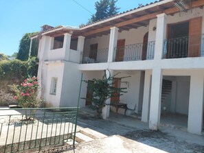 A two-story building with a balcony, a small garden, and a metal gate. - Antistoni Cozy  house in beautiful Agros with AC (Agros)