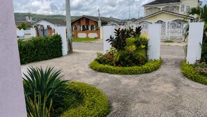 A residential area with houses, a gated entrance, and landscaped gardens. - 2BR Garden Suite – Minutes from a Glowing Lagoon (Falmouth)