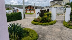 A residential area with houses, a gated entrance, and landscaped gardens. - 2BR Garden Suite – Minutes from a Glowing Lagoon (Falmouth)