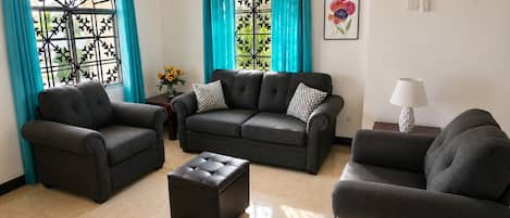 Ein Wohnzimmer mit einer Sofagarnitur, einem Couchtisch und einer Lampe.