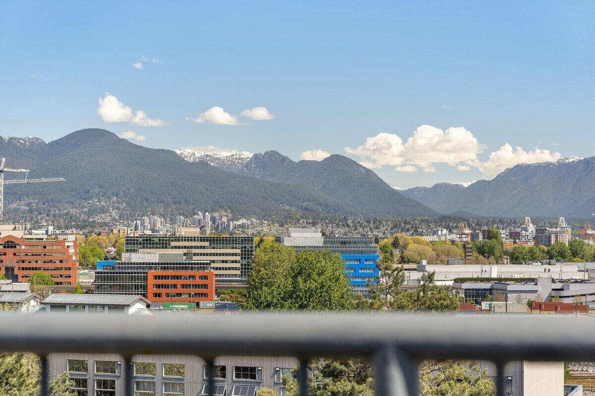 Un paisaje urbano con edificios modernos, una cordillera y un cielo despejado.