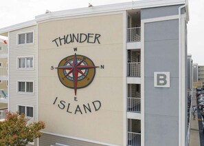 Ein Gebäude mit einem Kompassschild, der 'Thunder Island' anzeigt und einem Buchstaben 'B' an der Seite.