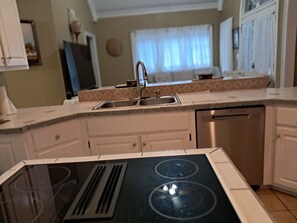 A kitchen with a double sink, white cabinets, and a built-in stove. - Quiet community, Family-friendly, ready to move in. 3 bedrooms, 2.5 bathrooms. (Statham)